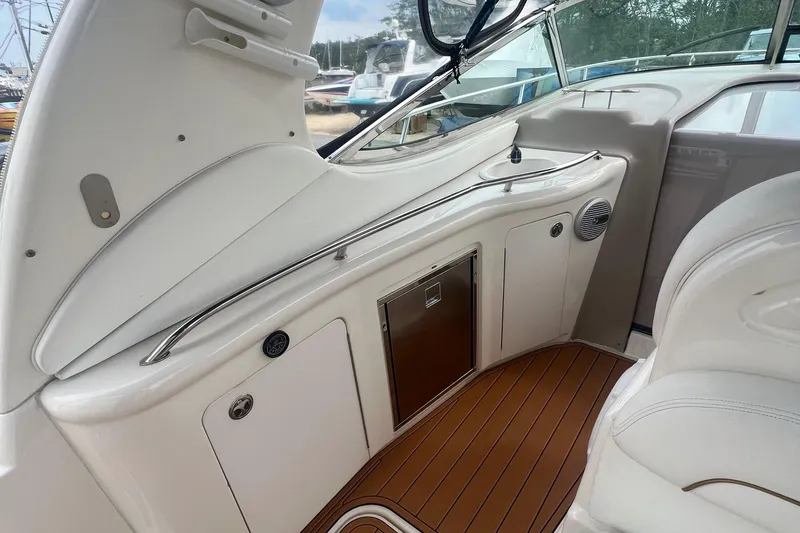Slide: The Image of Interior of 2002 Sea Ray 300 Sundancer boat with white seating and wooden flooring. - 17