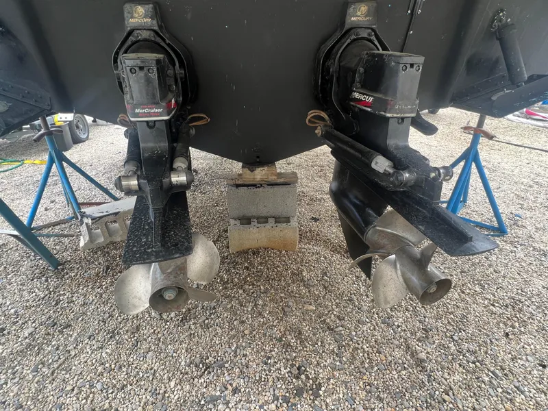 Slide: The Image of 2002 Sea Ray 300 Sundancer dual propellers on gravel surface. - 7