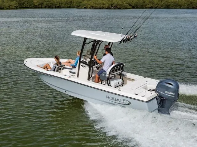 Slide: The Image of 2024 Robalo 226 Cayman boat cruising on a lake with passengers. - 25