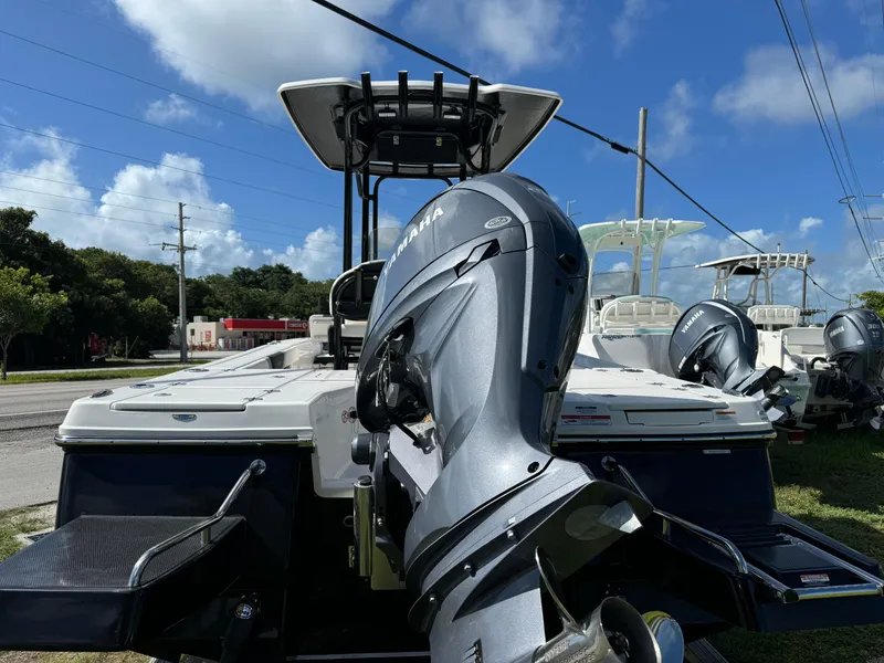 Slide: The Image of 2024 Robalo 226 Cayman boat with powerful outboard motor, parked outdoors under blue sky. - 3