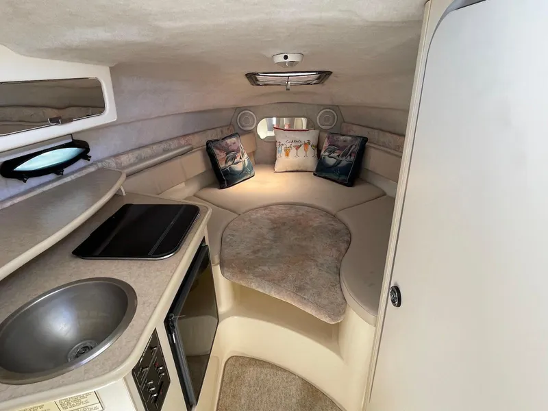 Slide: The Image of 2001 Stingray 240 CS boat cabin with kitchenette and seating area. - 2