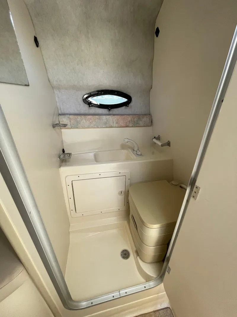 Slide: The Image of 2001 Stingray 240 CS boat bathroom with compact toilet and sink. - 5