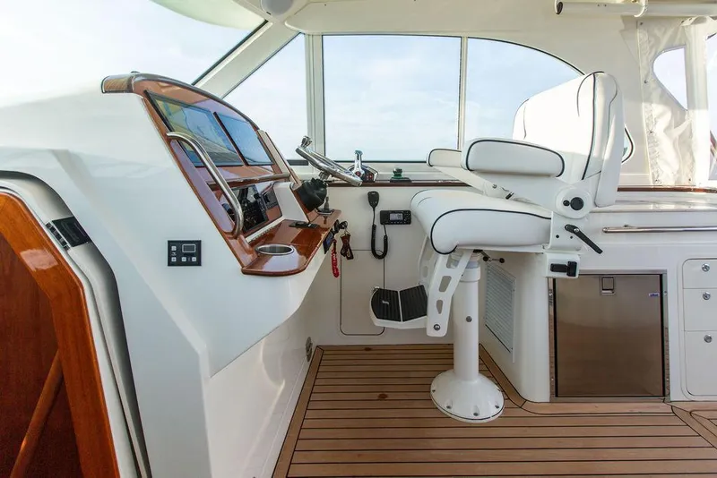 Slide: The Image of 2022 Hinckley Sport Boat 40 X interior with striped seating and wooden flooring. - 21