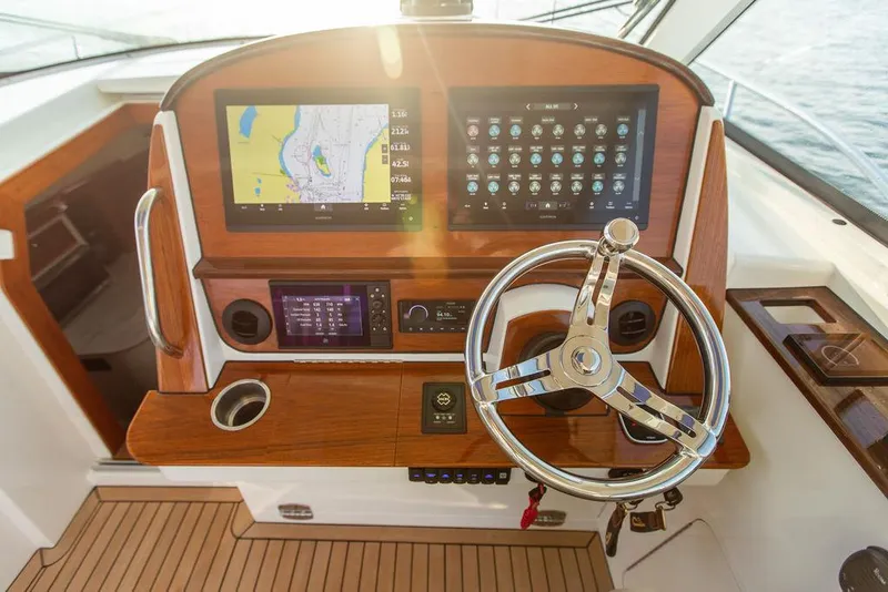 Slide: The Image of 2022 Hinckley Sport Boat 40 X interior with striped seating and ocean view. - 22