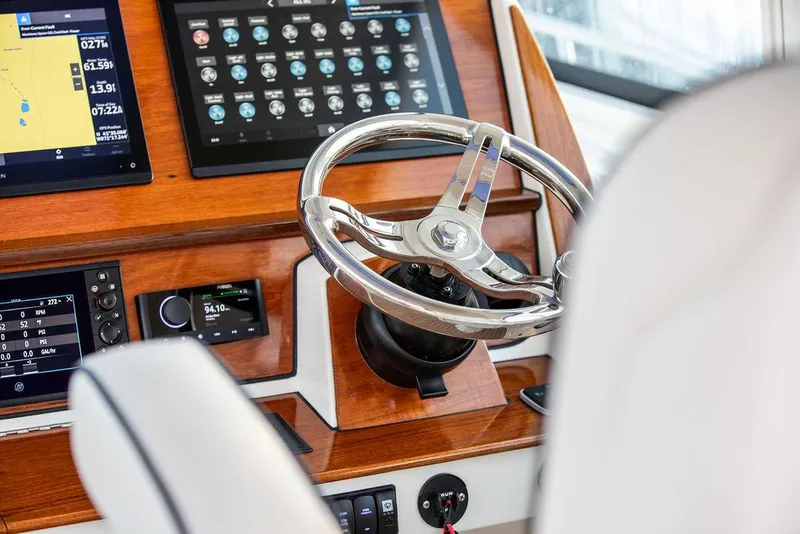 Slide: The Image of 2022 Hinckley Sport Boat 40 X on water, showcasing helm and seating area. - 25