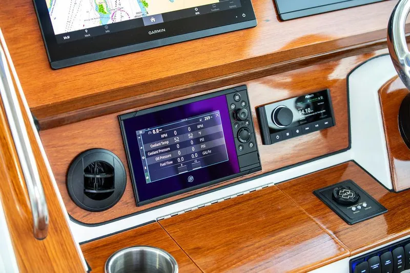 Slide: The Image of Hinckley Sport Boat 40 X 2022, elegant deck with striped seating, American flag, serene water view. - 27