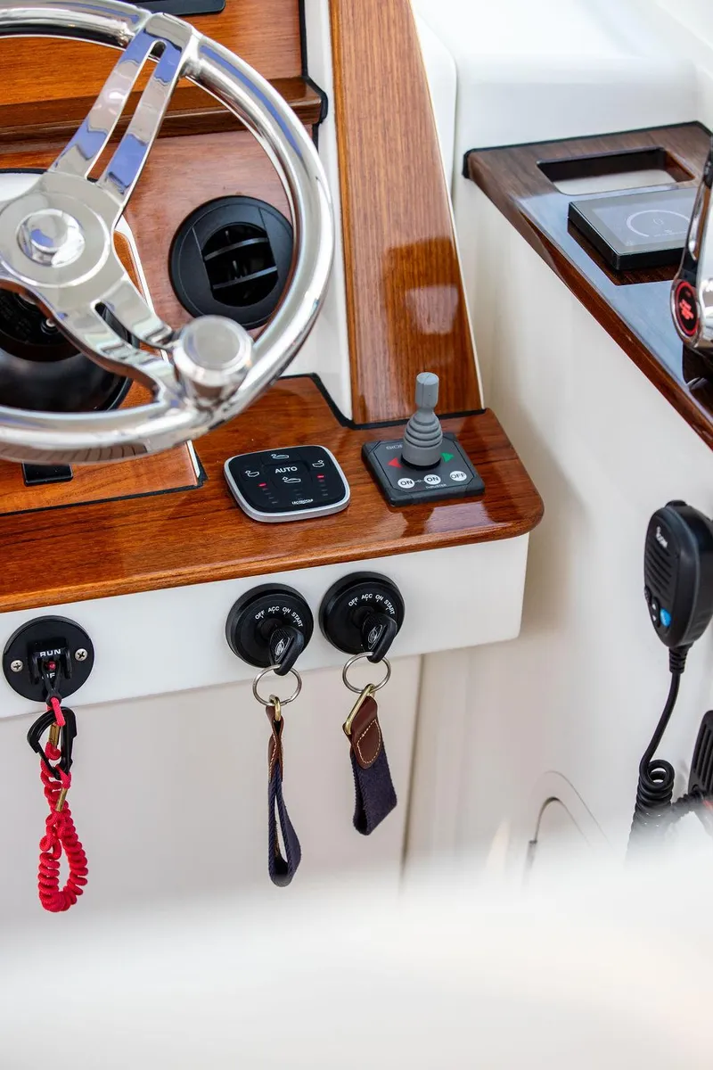 Slide: The Image of 2022 Hinckley Sport Boat 40 X interior with striped seating and wooden steps. - 30