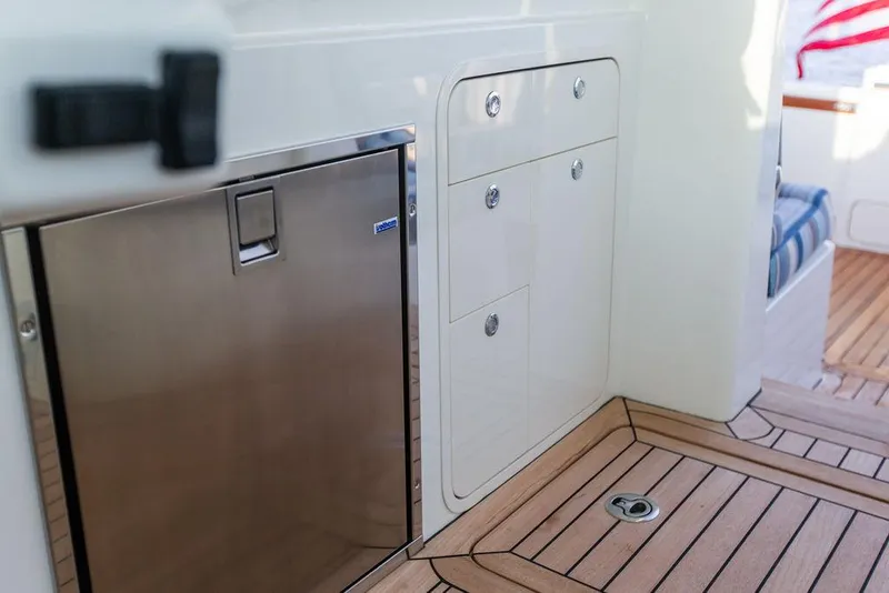 Slide: The Image of Hinckley Sport Boat 40 X 2022 interior with stainless steel fridge and wooden flooring. - 36