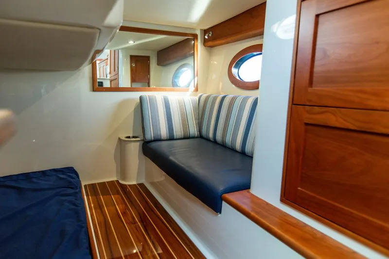 Slide: The Image of Interior cabin of 2022 Hinckley Sport Boat 40 X with wood accents and cozy bedding. - 47