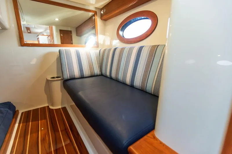 Slide: The Image of Interior of 2022 Hinckley Sport Boat 40 X with striped seating and wooden accents. - 48