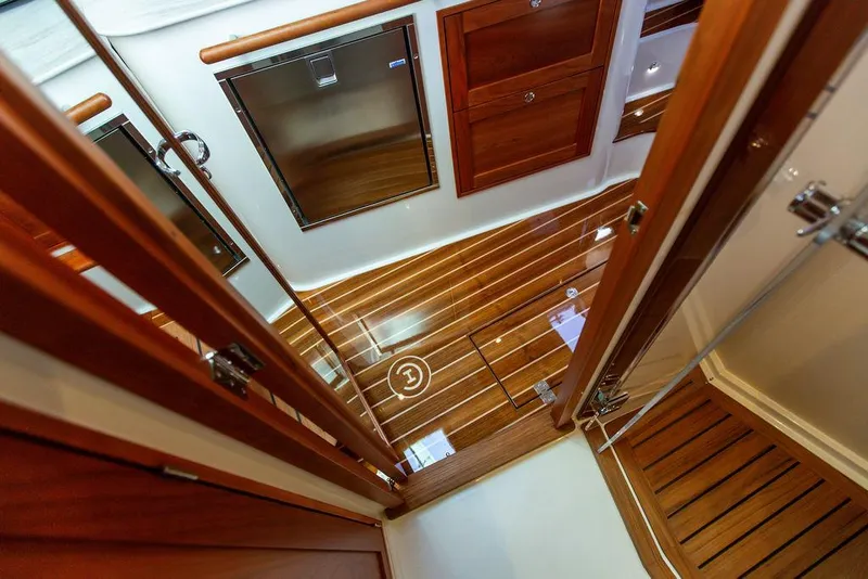 Slide: The Image of Interior of 2022 Hinckley Sport Boat 40 X with striped seating and wooden flooring. - 49