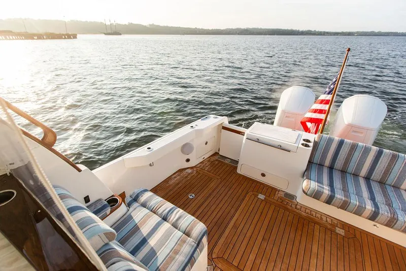 Slide: The Image of 2022 Hinckley Sport Boat 40 X cruising on a calm lake with forested shoreline. - 6