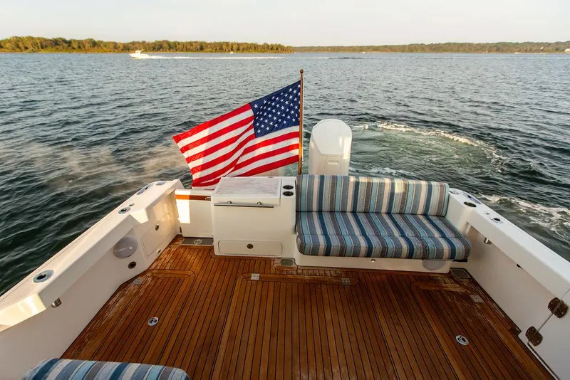 Slide: The Image of 2022 Hinckley Sport Boat 40 X cruising on a calm lake with scenic background. - 7