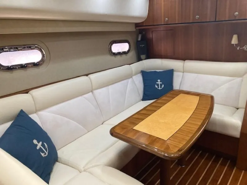 Slide: The Image of 2006 Tiara Yachts 4300 Sovran Express Cruiser interior with white seating and wooden table. - 20