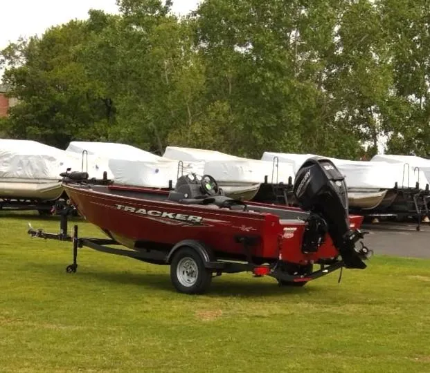 Slide: The Image of 2024 Tracker Super Guide V-16 SC boat on trailer, parked on grass. - 2