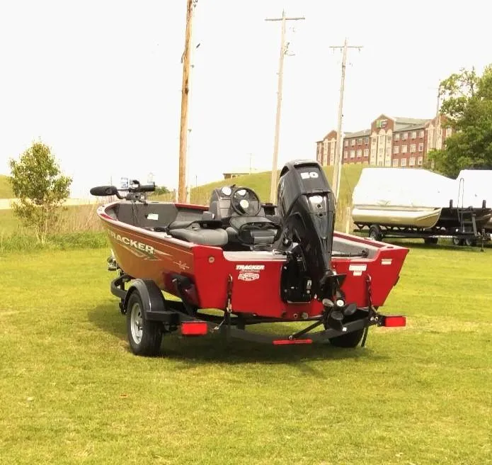 Slide: The Image of 2024 Tracker Super Guide V-16 SC boat on grass, rear view, with outboard motor. - 5