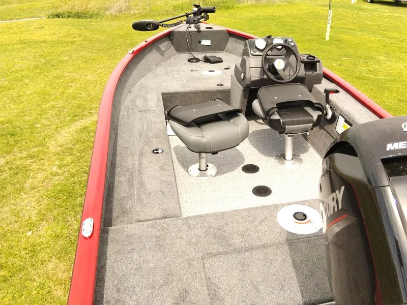 Slide: The Image of 2024 Tracker Super Guide V-16 SC boat with seating and Mercury engine on grassy area. - 6