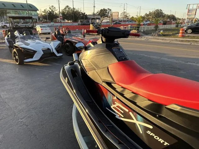 Slide: The Image of 2024 Yamaha Marine Waverunner EX SPORT in black and cyan, parked near sports cars. - 13