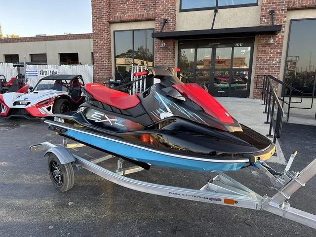 Slide: The Image of 2024 Yamaha Marine Waverunner EX SPORT storage compartment with red rope, black and cyan design. - 5