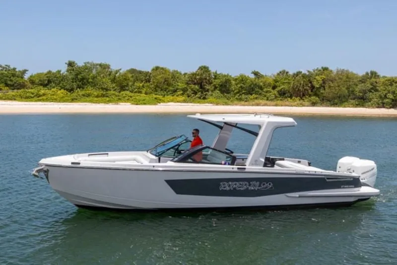 The Image of 2020 Aviara AV32 OB boat cruising on a calm lake near a forested shoreline. - 0