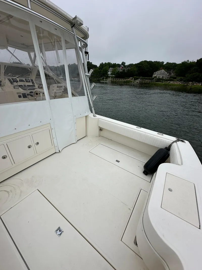 Slide: The Image of 2006 Carolina Classic 28FT boat with spacious deck, docked by a serene waterfront. - 9