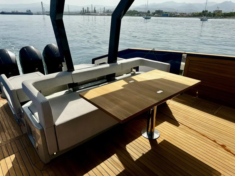 Slide: The Image of Aicon Audace 50 yacht deck with seating and table, 2025 model, on calm water. - 40