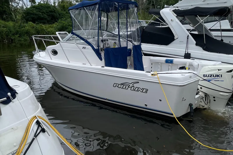 Slide: The Image of 2015 Pro-Line 20 Express Cuddy boat docked with Suzuki outboard motor. - 0