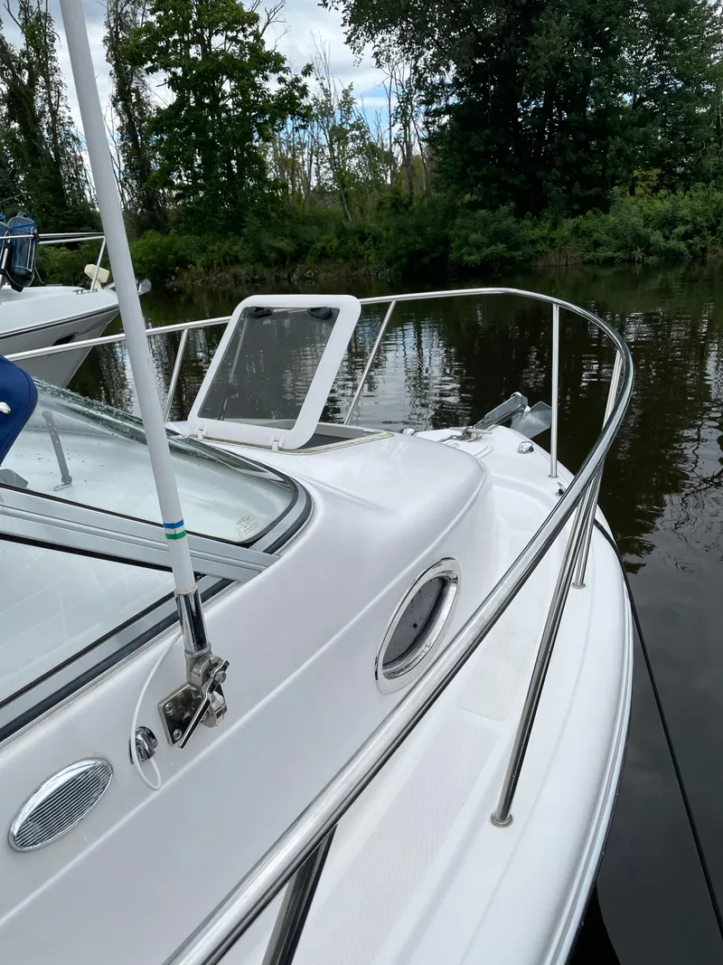 Slide: The Image of 2015 Pro-Line 20 Express Cuddy boat on calm water near trees. - 11