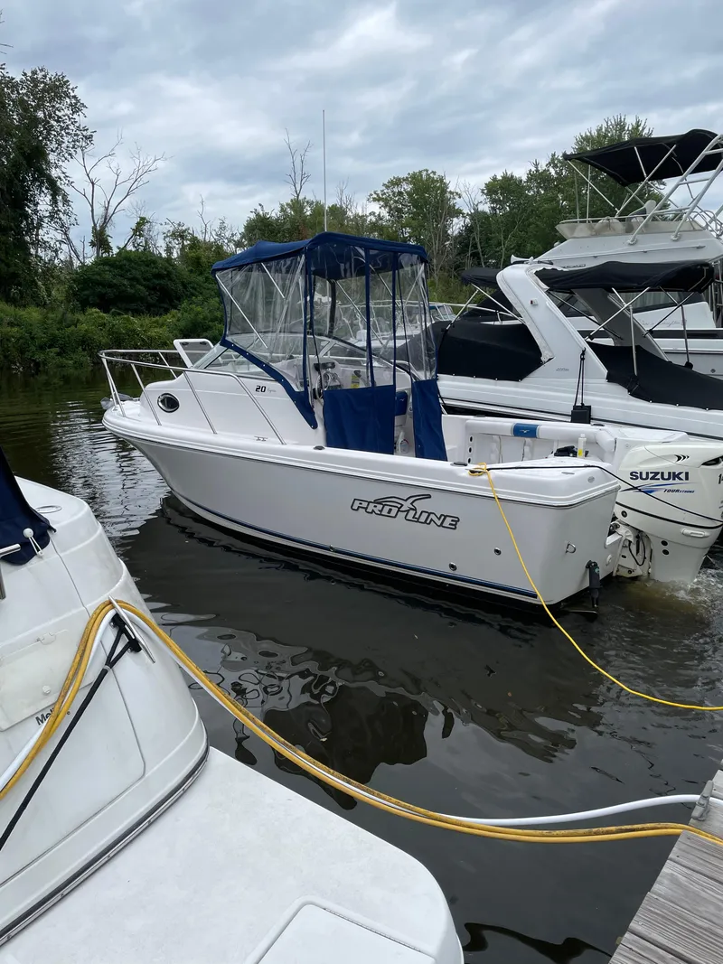 Slide: The Image of 2015 Pro-Line 20 Express Cuddy boat docked in a marina. - 13