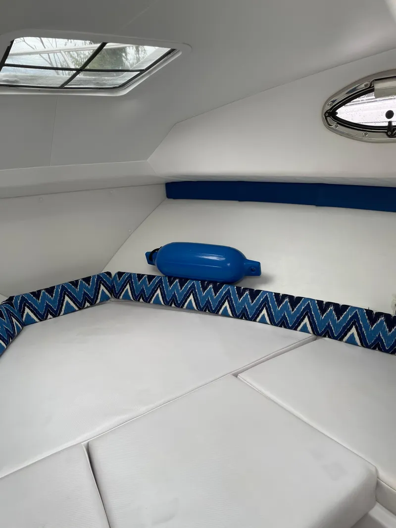 Slide: The Image of Interior cabin of a 2015 Pro-Line 20 Express Cuddy boat with blue accents. - 14