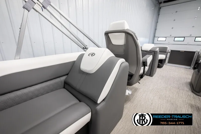 Slide: The Image of 2024 Avalon LSZ QL boat interior with gray and white seating, Reeder-Trausch Marine logo. - 21