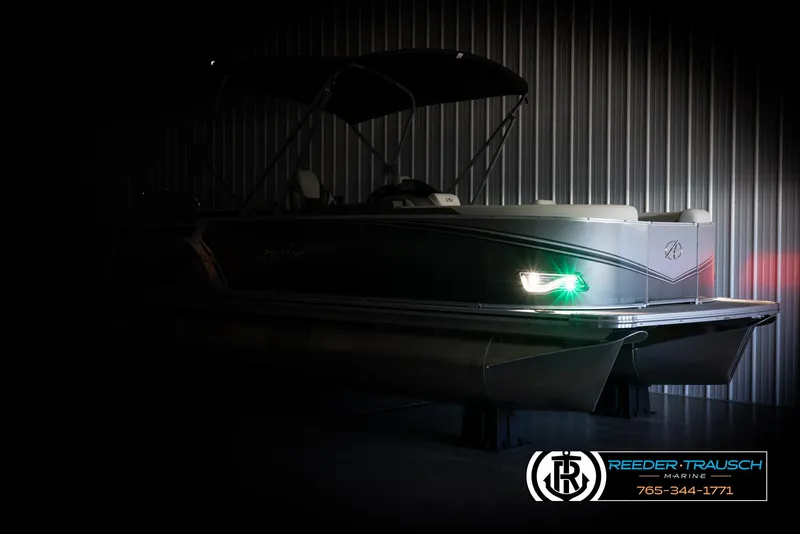 Slide: The Image of 2024 Avalon LSZ QL pontoon boat with illuminated navigation lights in a dimly lit storage area. - 4