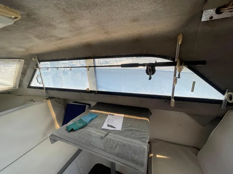 Slide: The Image of Interior of a 1976 Allmand 25 Express Inboard boat with fishing rod and table. - 26