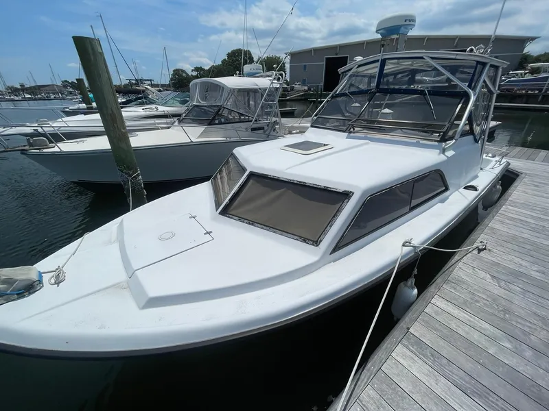 Slide: The Image of 1976 Allmand 25 Express Inboard boat docked at a marina. - 37