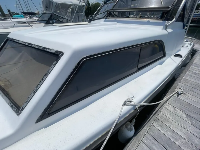 Slide: The Image of 1976 Allmand 25 Express Inboard boat docked at marina. - 38