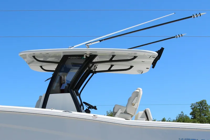 Slide: The Image of 2025 World Cat 280 CC-X boat with T-top and fishing rods against clear blue sky. - 12
