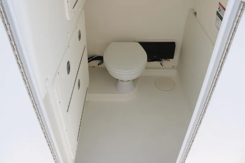 Slide: The Image of 2025 World Cat 325 CC boat interior bathroom with toilet and storage compartments. - 12