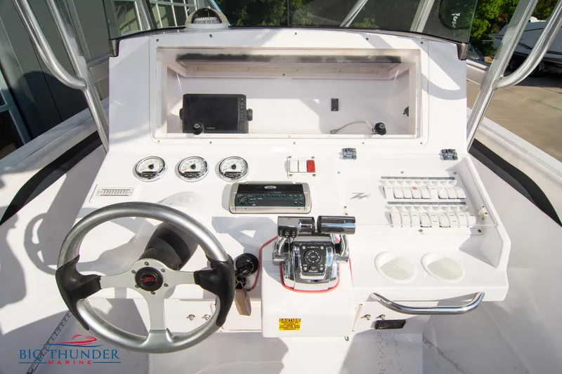 Slide: The Image of 2005 Donzi 32 ZF boat dashboard with steering wheel and control panel. - 27