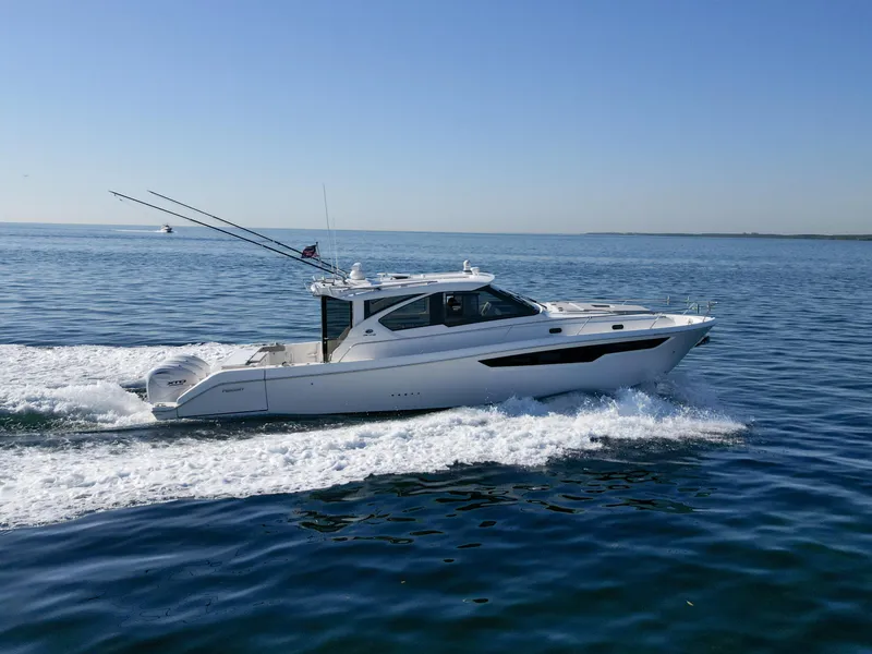 Slide: The Image of 2024 Pursuit OS 445 Offshore cruising on open water under clear skies. - 10