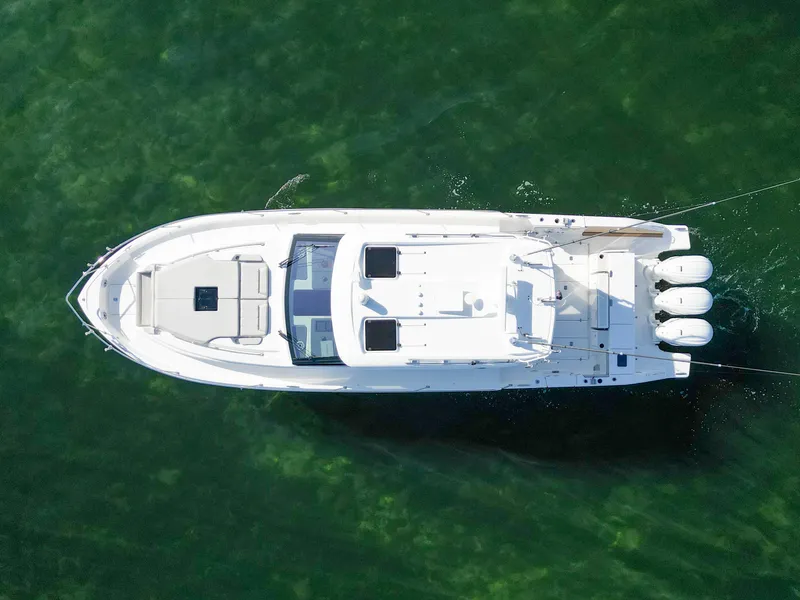 Slide: The Image of Aerial view of 2024 Pursuit OS 445 Offshore boat on clear green water. - 15