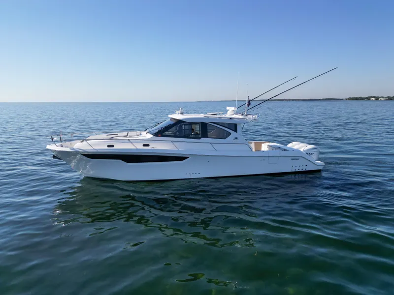 Slide: The Image of 2024 Pursuit OS 445 Offshore boat on calm sea under clear sky. - 17