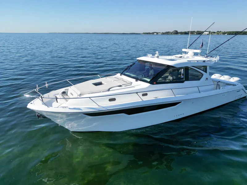 Slide: The Image of 2024 Pursuit OS 445 Offshore boat on calm water, showcasing sleek design and luxury features. - 18