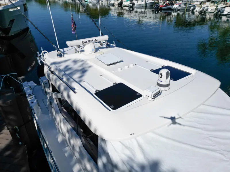 Slide: The Image of 2024 Pursuit OS 445 Offshore boat docked, featuring Garmin equipment on the roof. - 19