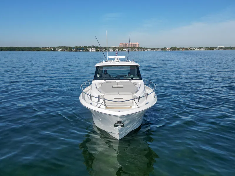 Slide: The Image of 2024 Pursuit OS 445 Offshore boat on calm water, clear sky background. - 25