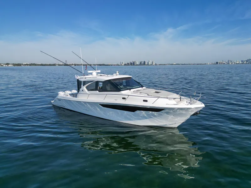 Slide: The Image of 2024 Pursuit OS 445 Offshore boat on calm water under clear blue sky. - 27