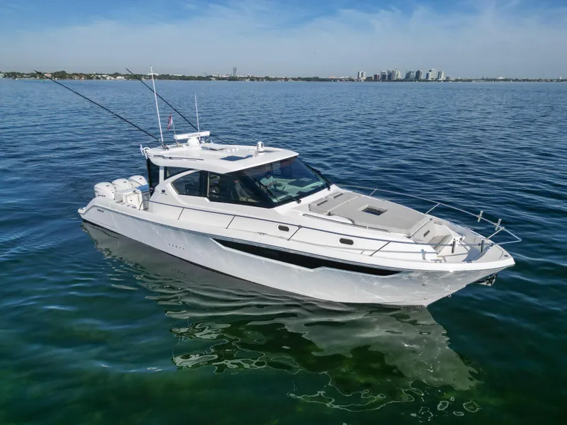 Slide: The Image of 2024 Pursuit OS 445 Offshore boat on calm water, city skyline in background. - 3