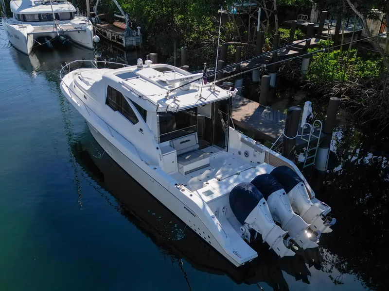 Slide: The Image of 2024 Pursuit OS 445 Offshore boat docked in a serene marina setting. - 4