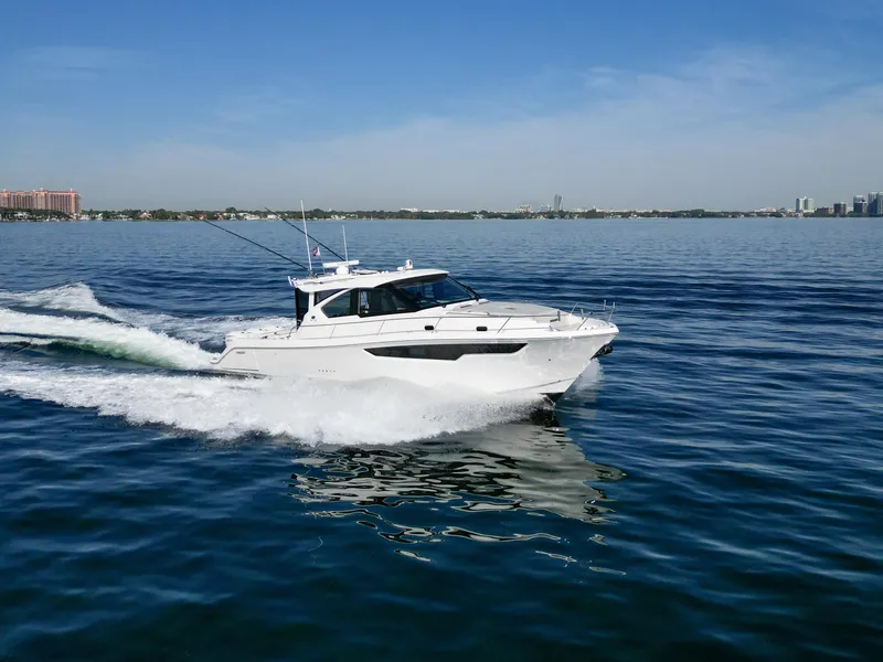 Slide: The Image of 2024 Pursuit OS 445 Offshore cruising on open water under clear skies. - 9