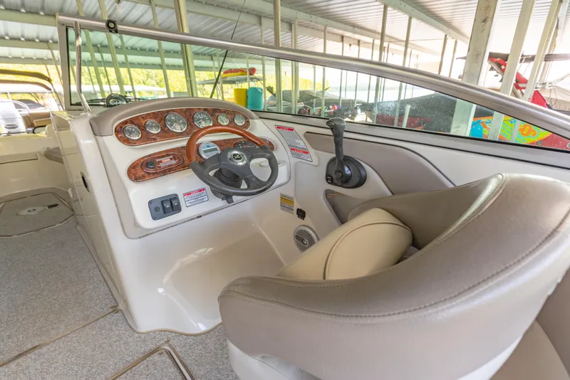 Slide: The Image of 2004 Sea Ray 240 Sundeck boat interior with steering wheel and control panel. - 10