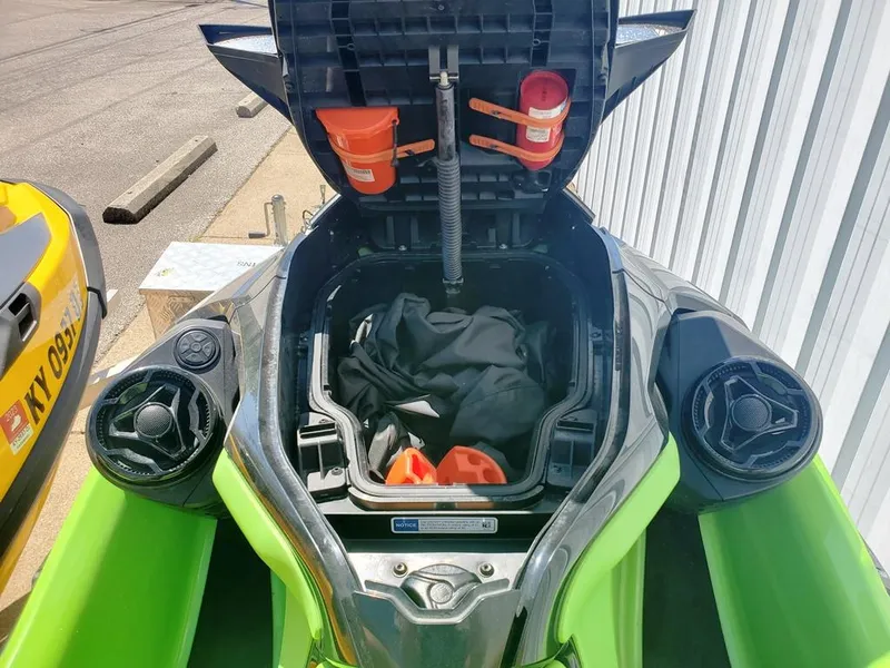 Slide: The Image of 2021 Sea-Doo RXT with open storage compartment showing safety gear and accessories. - 12
